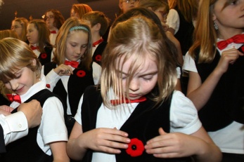 EDMONTON, ALBERTA, OCTOBER 29, 2009 - Vicki Torrie(left) from Kingsway Legion pins a poppy on Devon Kuzik, 8, and Meghan Doig, 8, arranges her poppy during the Poppy Fund launch for 2009 at Kingsway Legion Thursday afternoon. The two were members of The Singing Ravens Choir from Mills Haven Elementary School in Sherwood Park. In Edmonton, October 29/09. (Rick MacWilliam/Edmonton Journal)